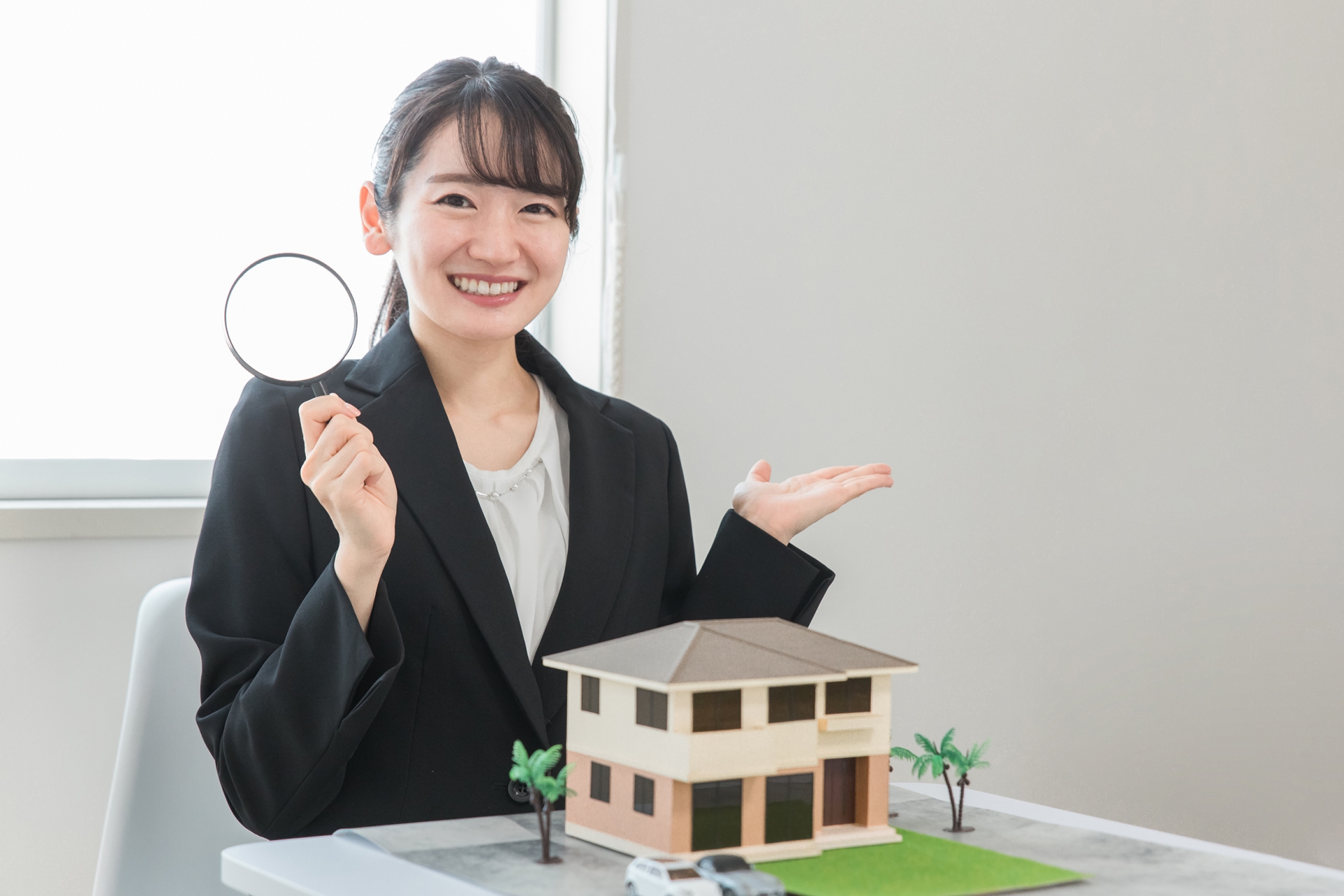 住宅模型を前に物件探しをサポートするジョイハウスのスタッフ