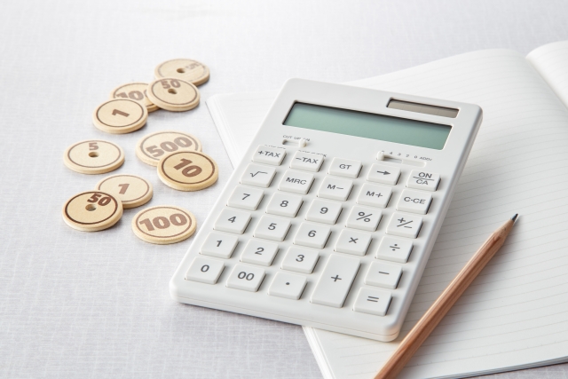 電卓と硬貨でローン返済額を計算するイメージ